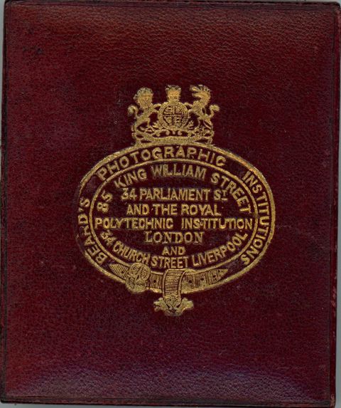 Case. Burgundy-red leather case is stamped with a gold insignia and text.